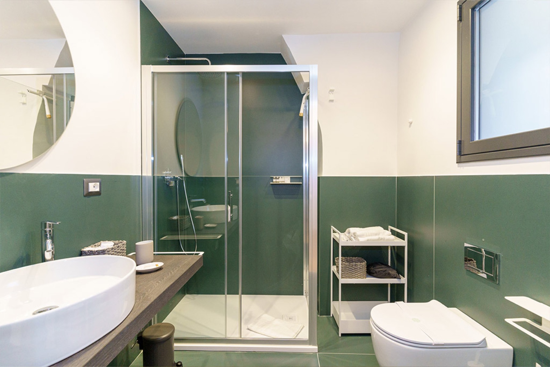 Bagno di Casa San Berillo con piastrelle verdi e ampia doccia in vetro