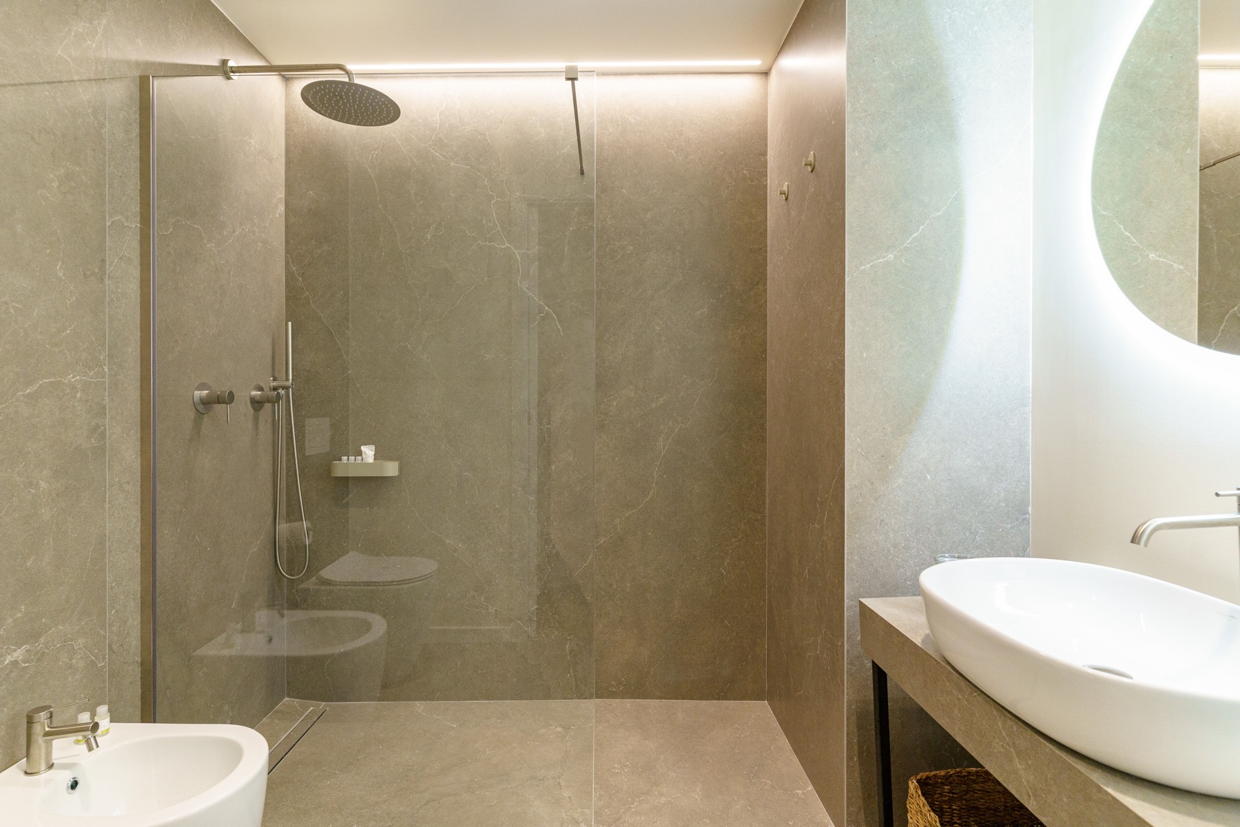 Bagno di Casa Santa Brigida con doccia walk-in in pietra e specchio tondo