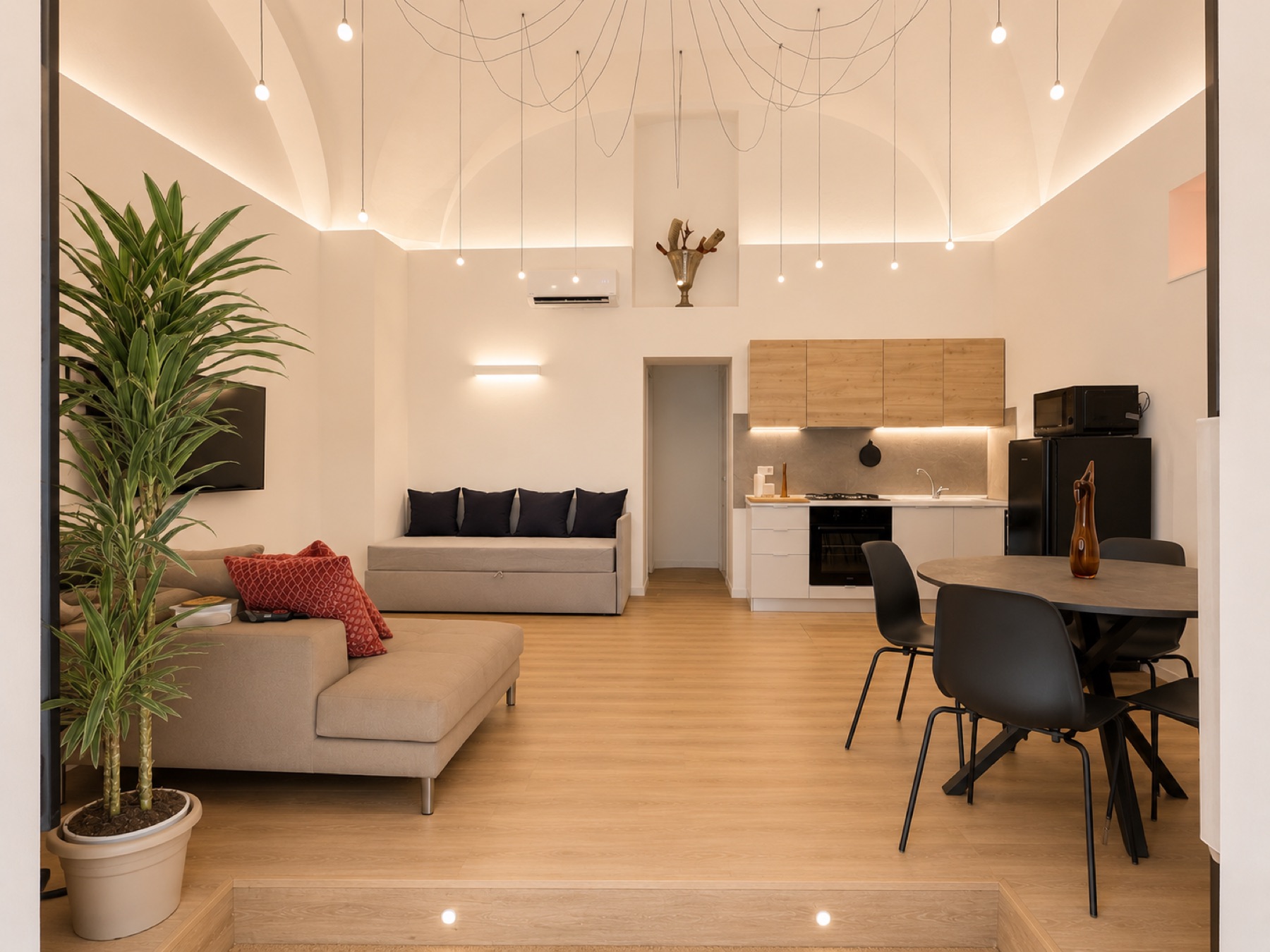 Ampia zona living di Casa Santa Brigida con soffitto a volta, divani e zona pranzo