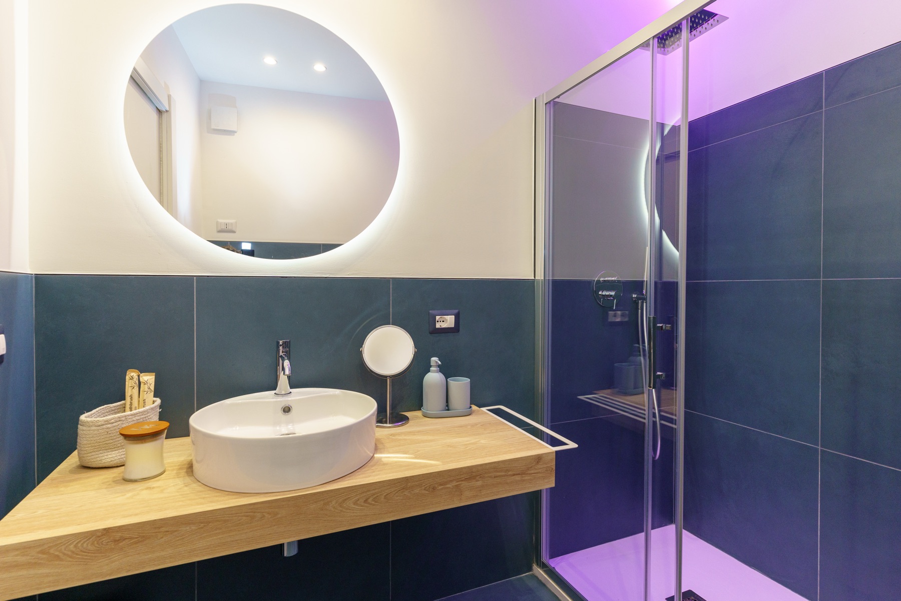 Bagno di Casa Sant'Elmo con lavabo su piano in legno e specchio retroilluminato