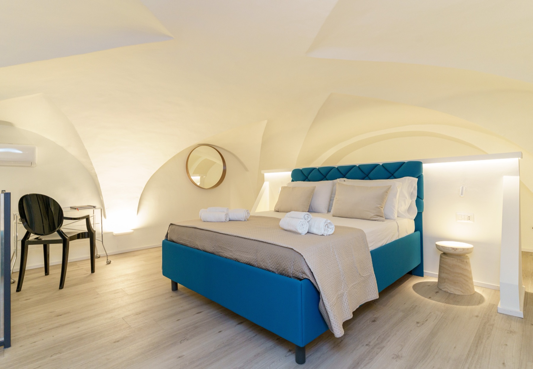 Camera soppalcata di Casa Sant'Elmo con soffitto a volta e letto con testiera blu