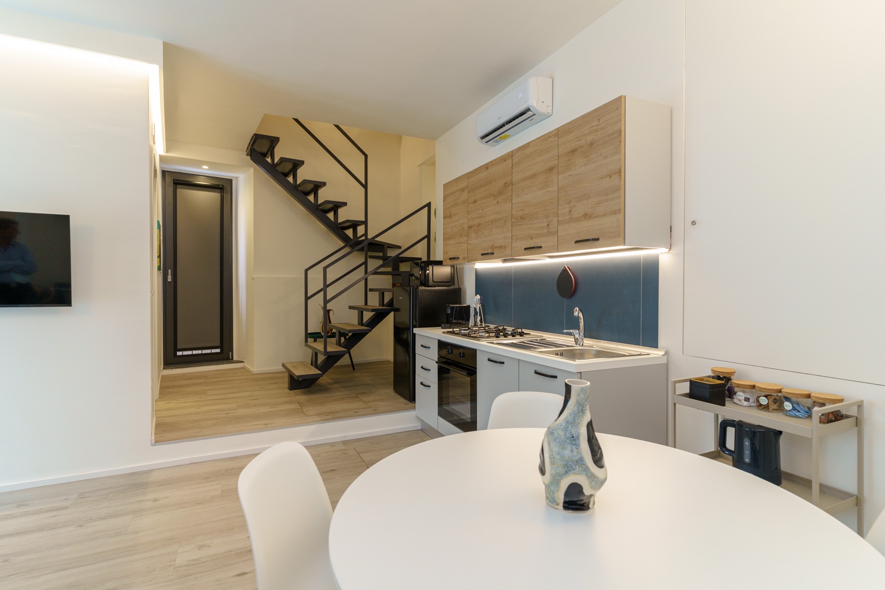 Zona living di Casa Sant'Elmo con cucina e scala verso il soppalco